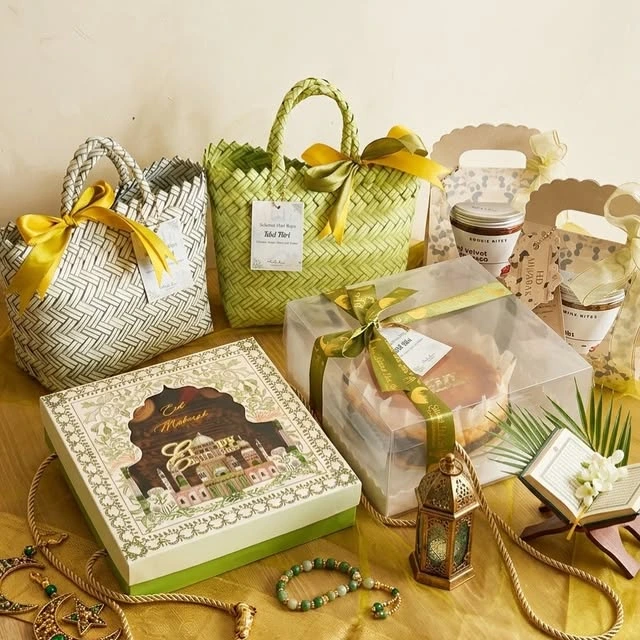 Hamper Lebaran Hibiku dengan keranjang hijau, pita, dan kotak hadiah